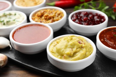 Different tasty sauces in bowls on table, closeup