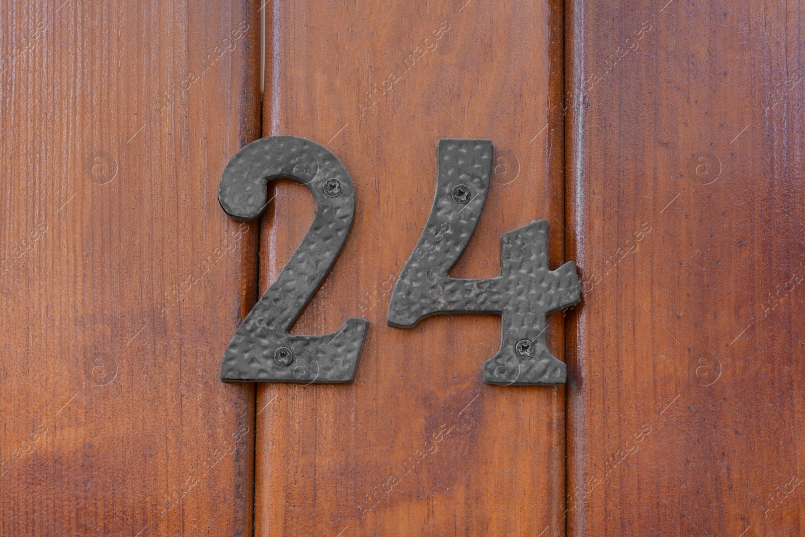 Photo of House number twenty four on wooden door, closeup