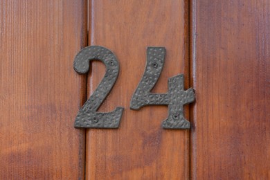 Photo of House number twenty four on wooden door, closeup