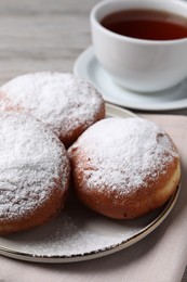 Delicious sweet buns and cup of tea on table, closeup