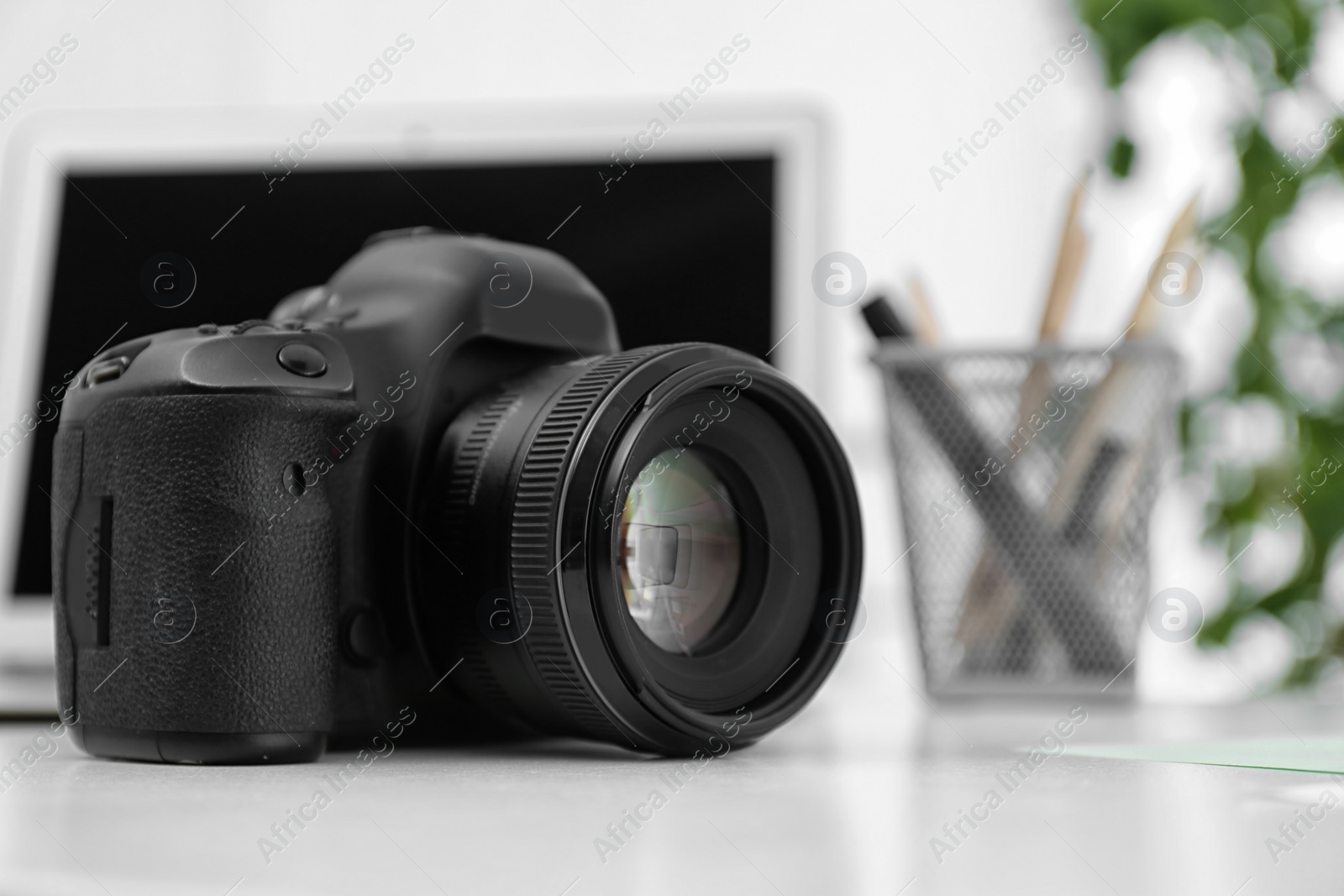 Photo of Digital camera on white table. Equipment for professional photographer