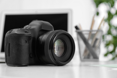 Digital camera on white table. Equipment for professional photographer