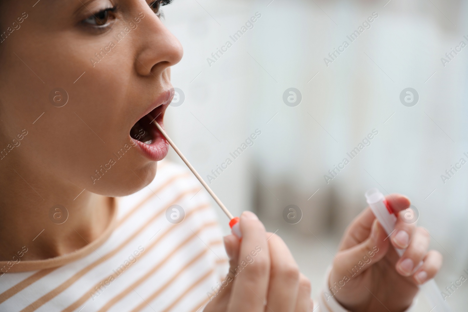 Photo of Woman taking sample for DNA test indoors, closeup