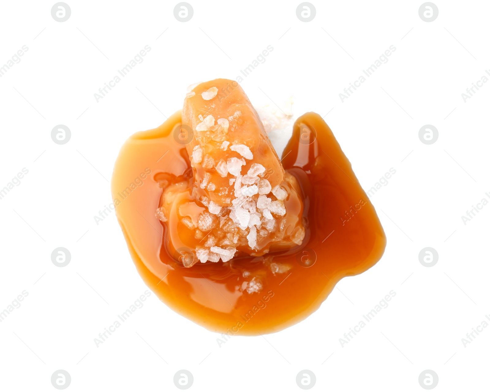 Photo of Yummy caramel candies and sea salt isolated on white, top view