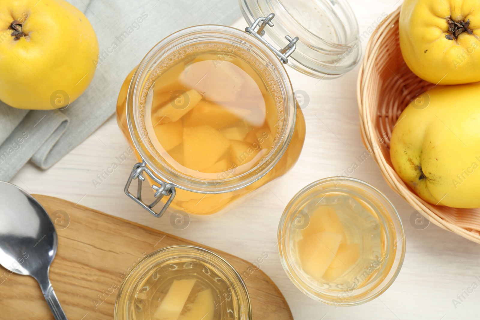 Photo of Delicious quince drink, fresh fruits and spoon on white wooden table, flat lay