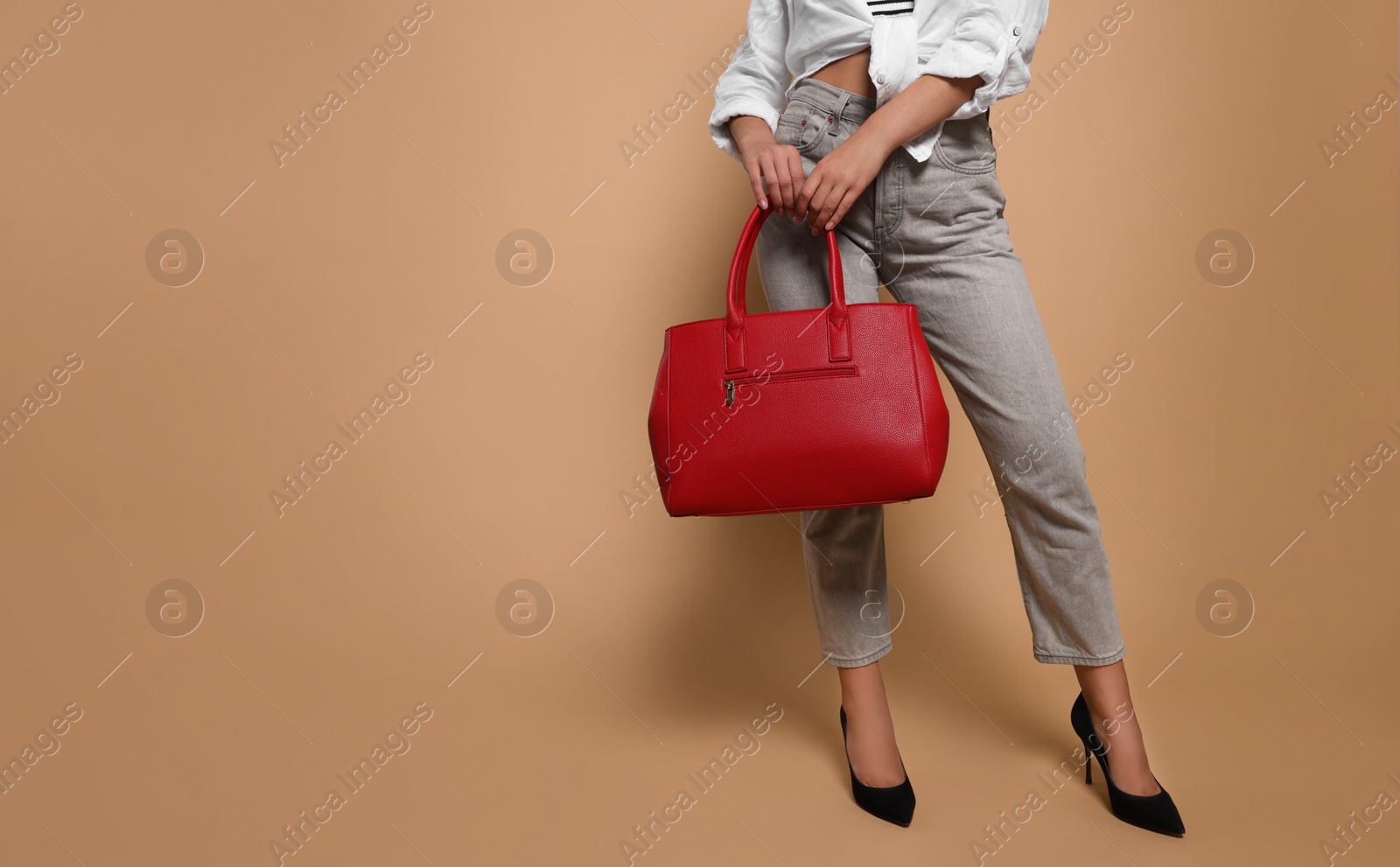 Photo of Young woman with stylish bag on beige background, closeup. Space for text