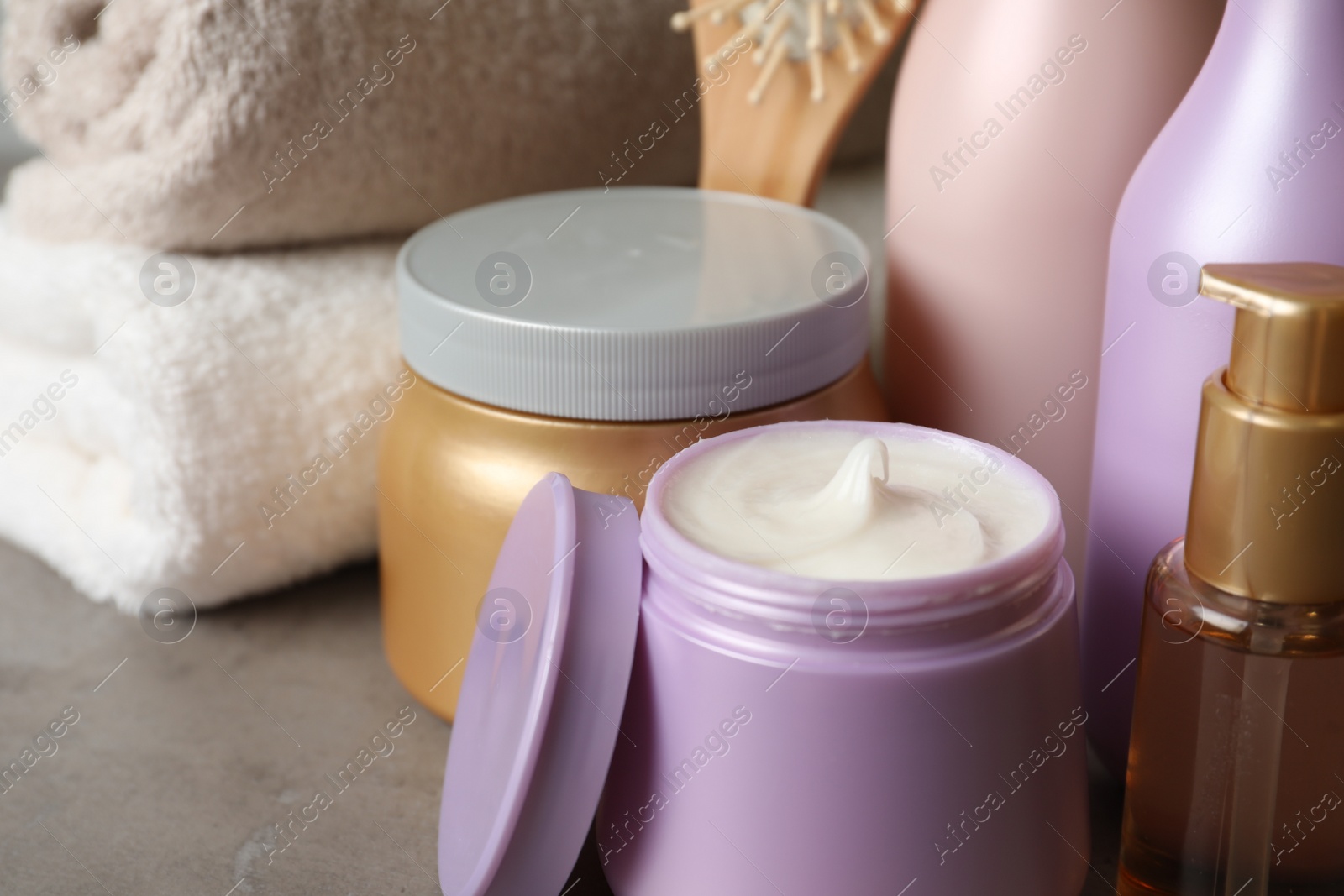 Photo of Different hair products on grey table, closeup