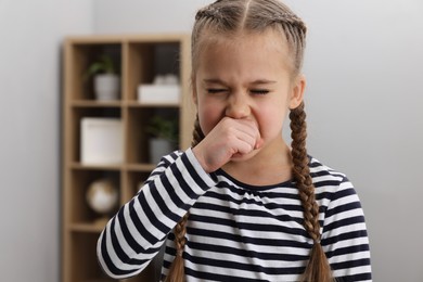 Sick girl coughing at home. Cold symptoms