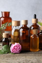 Photo of Aromatherapy. Different essential oils and flower on wooden table