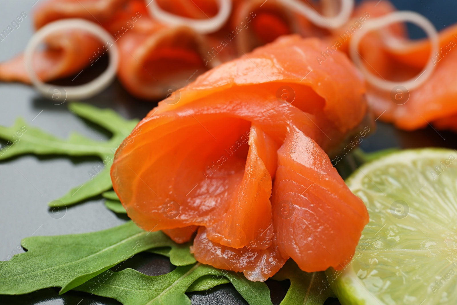 Photo of Fresh sliced salmon fillet, lemon and arugula, closeup