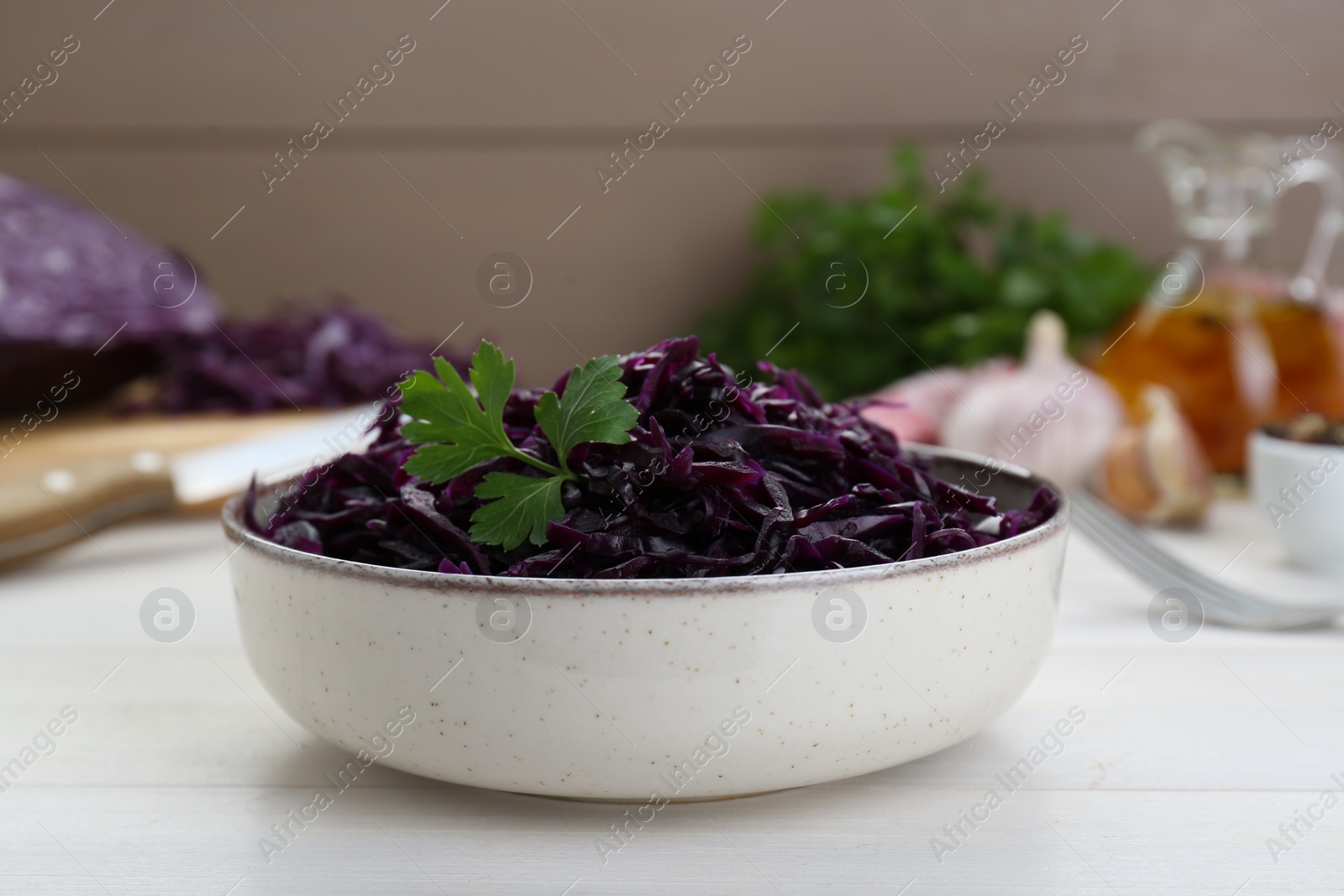 Photo of Tasty red cabbage sauerkraut with parsley on white wooden table