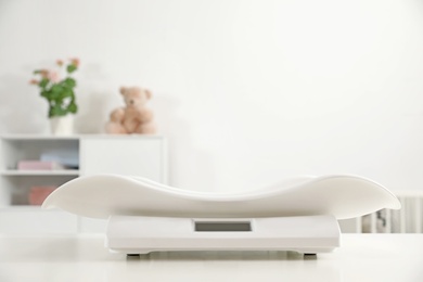 Modern digital baby scales on table in room. Space for text