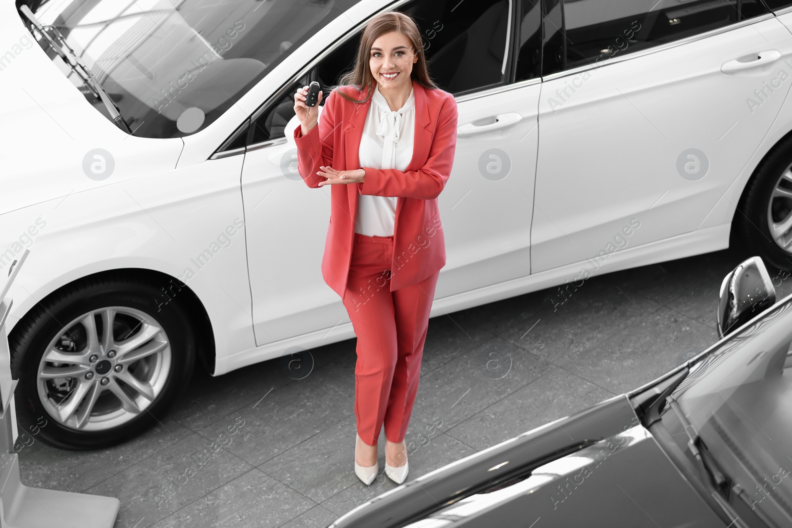 Photo of Young woman holding car key in salon