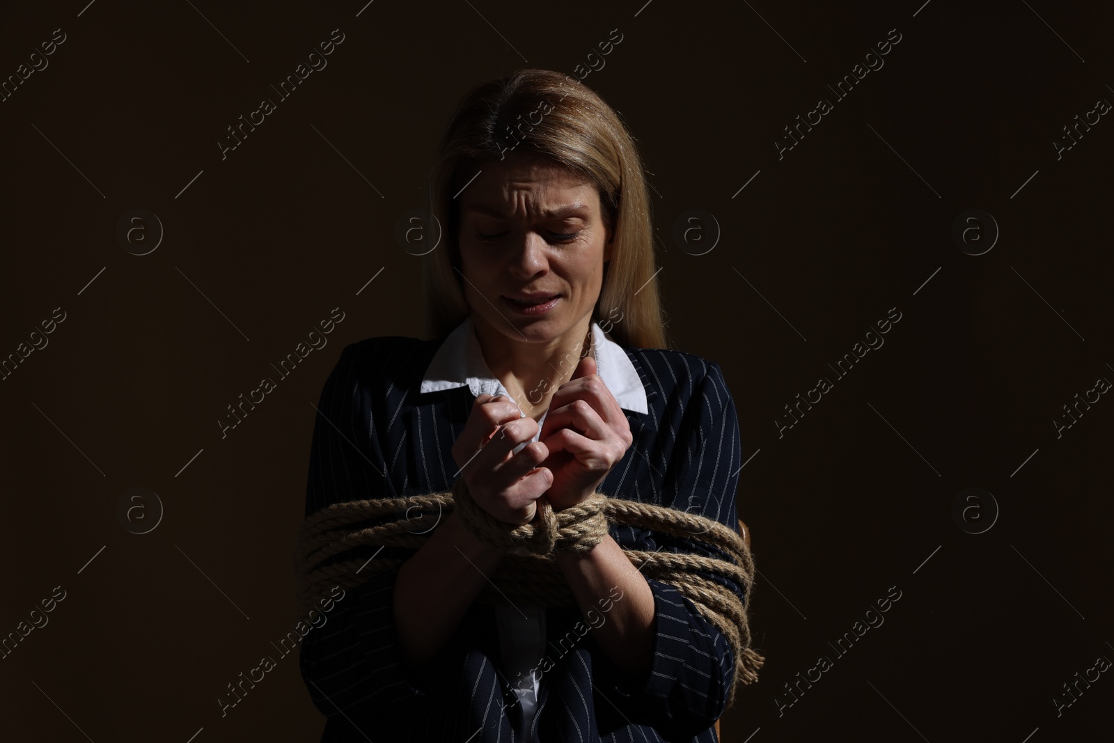Photo of Woman tied up and taken hostage on dark background