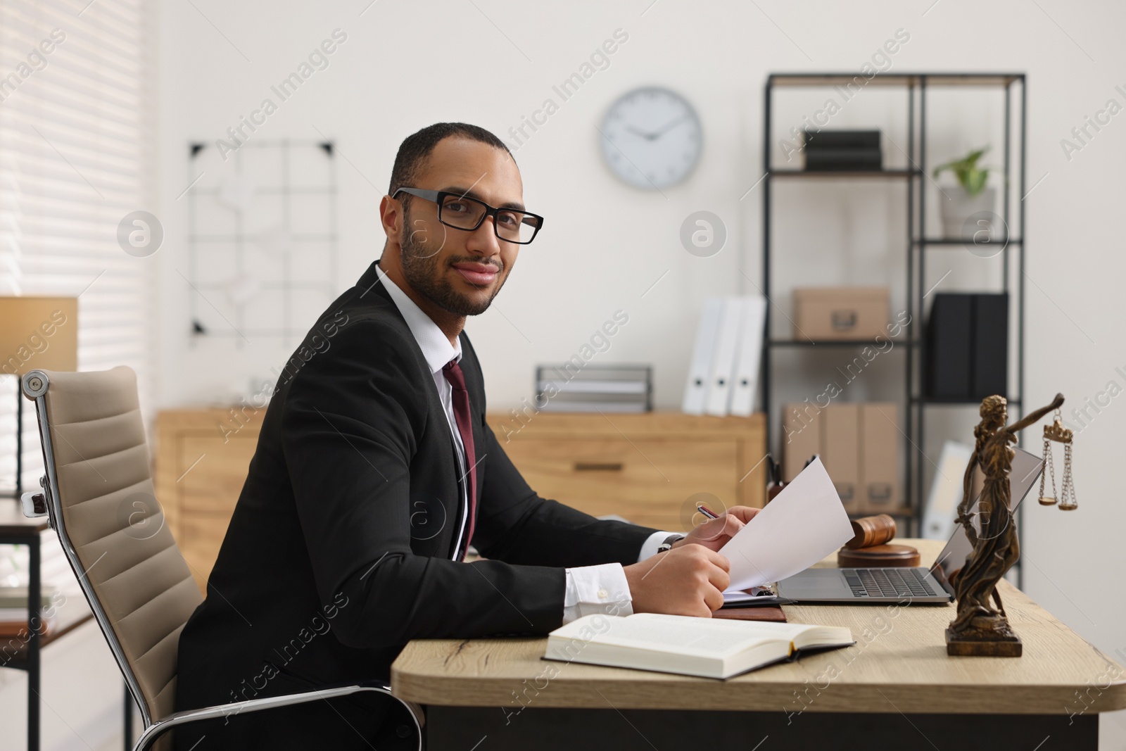 Photo of Confident lawyer working with document at table in office