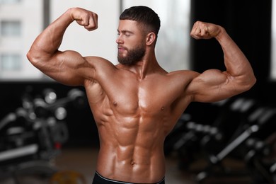 Image of Handsome bodybuilder showing his muscular body in gym