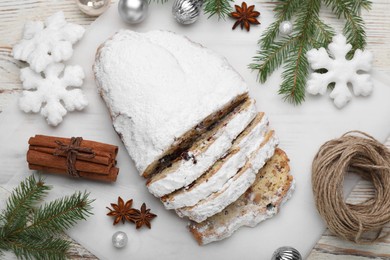 Traditional Christmas Stollen with icing sugar on white wooden table, flat lay