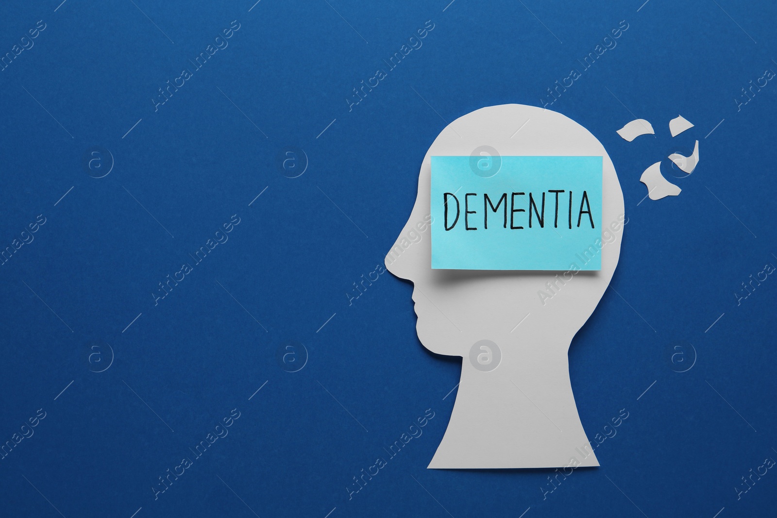 Photo of Human head cutout with word Dementia on blue background, flat lay. Space for text