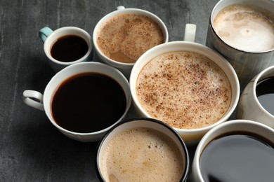 Many cups of different coffees on slate table