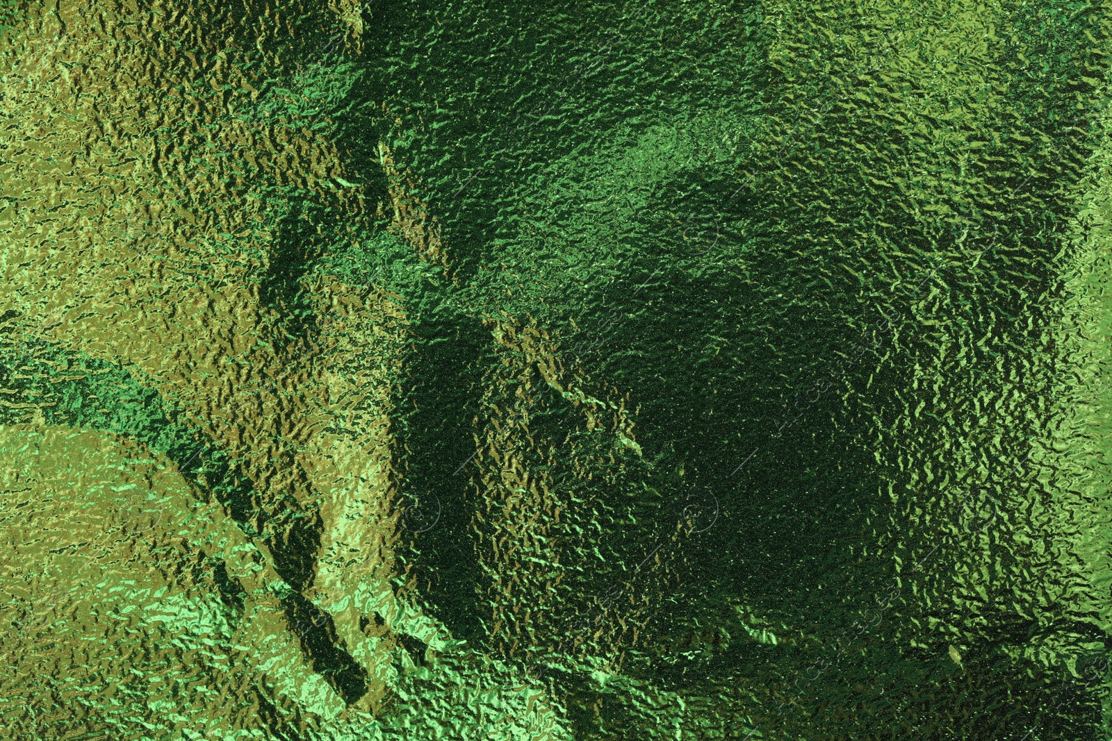 Photo of Textured green foil as background, top view