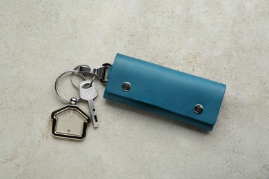 Photo of Leather case with key on light grey table, top view