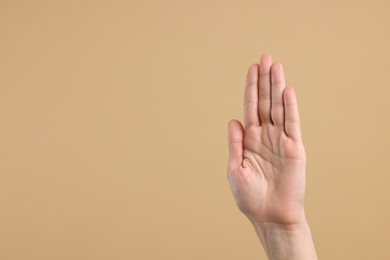 Photo of Woman giving high five on light brown background, closeup. Space for text