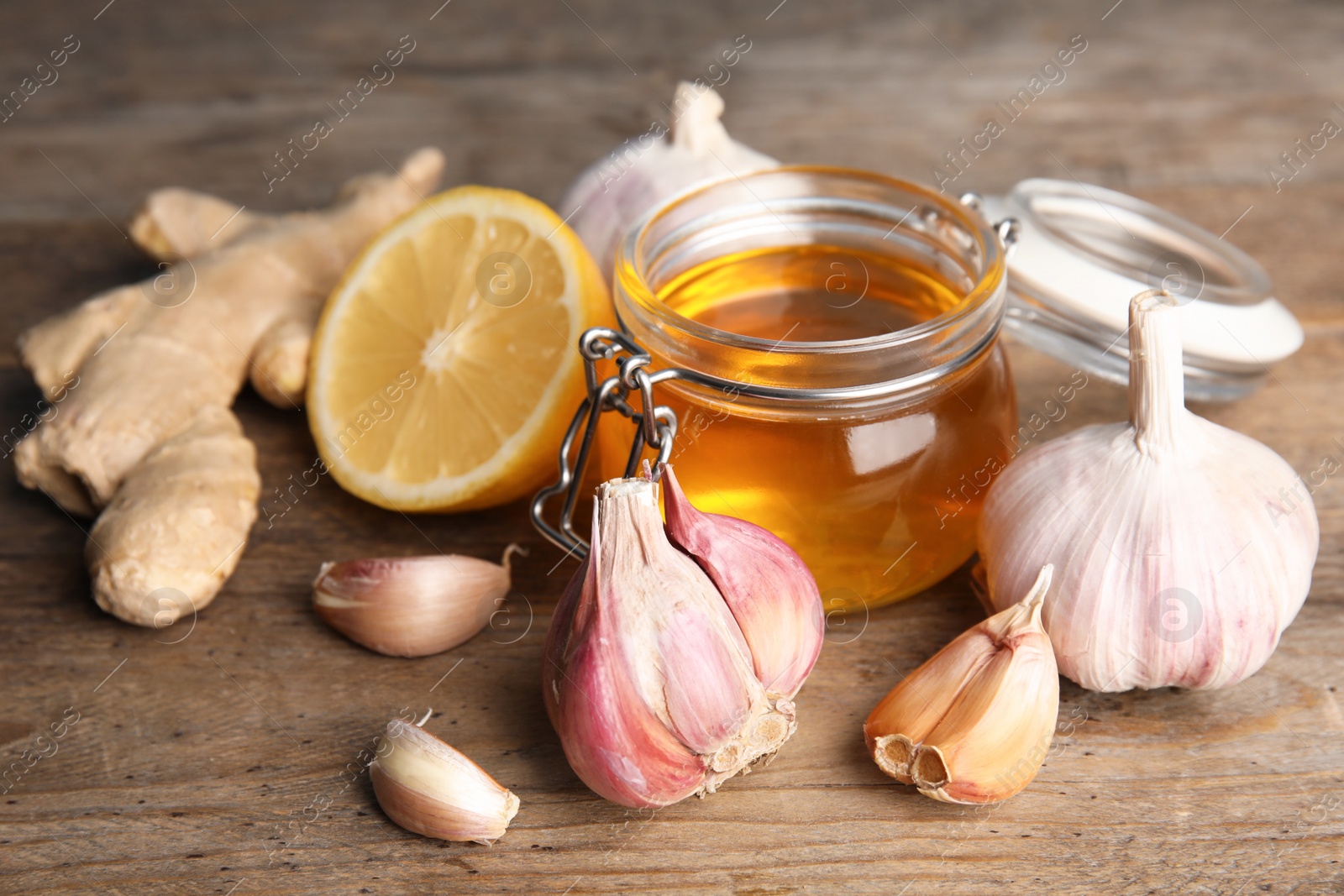 Photo of Composition with garlic and other cold remedies on wooden table