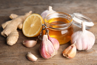 Composition with garlic and other cold remedies on wooden table