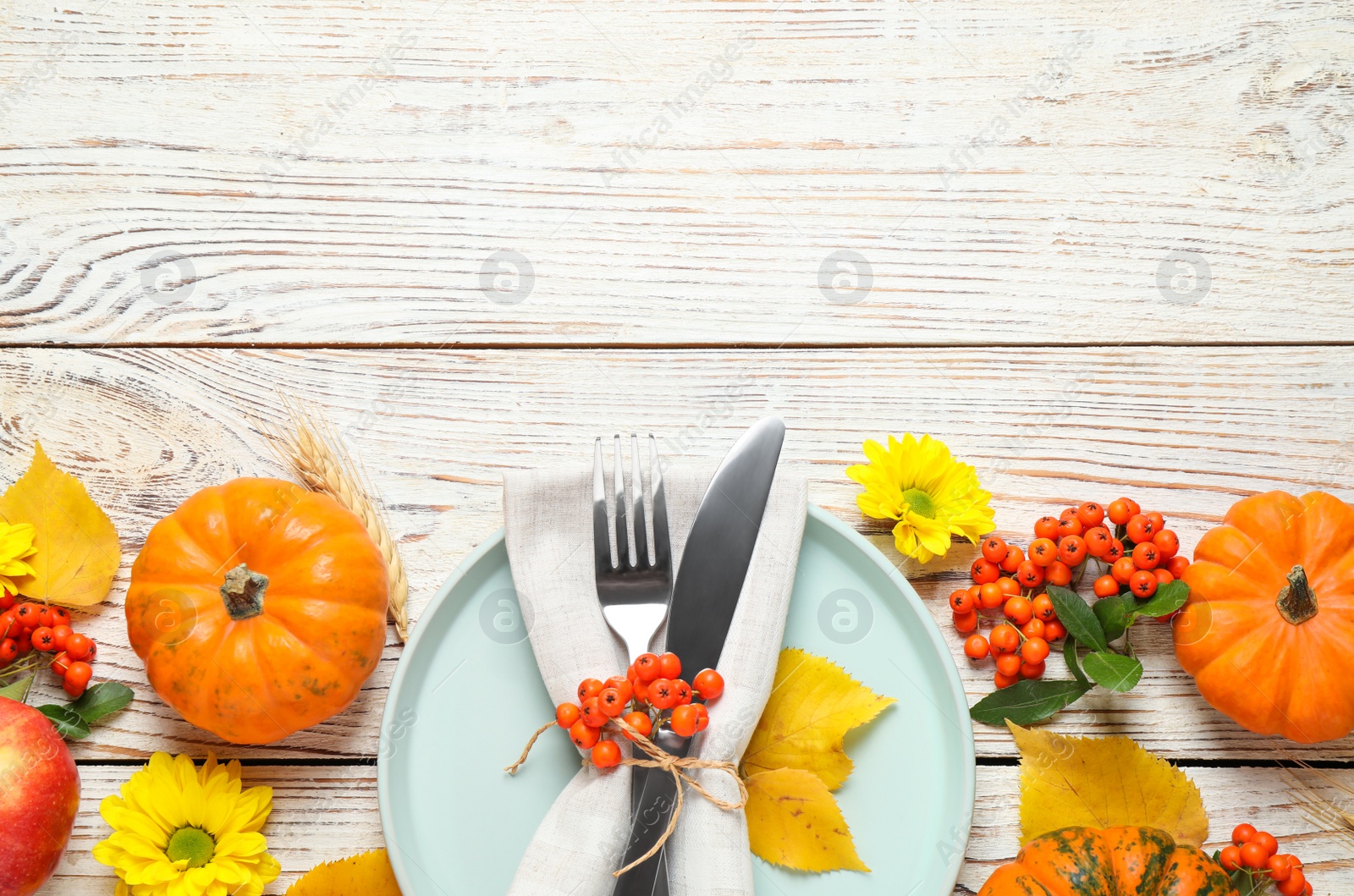 Photo of Flat lay composition with tableware, autumn leaves and pumpkins on white wooden background, space for text. Thanksgiving Day