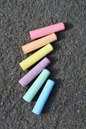 Colorful chalk sticks on asphalt, flat lay