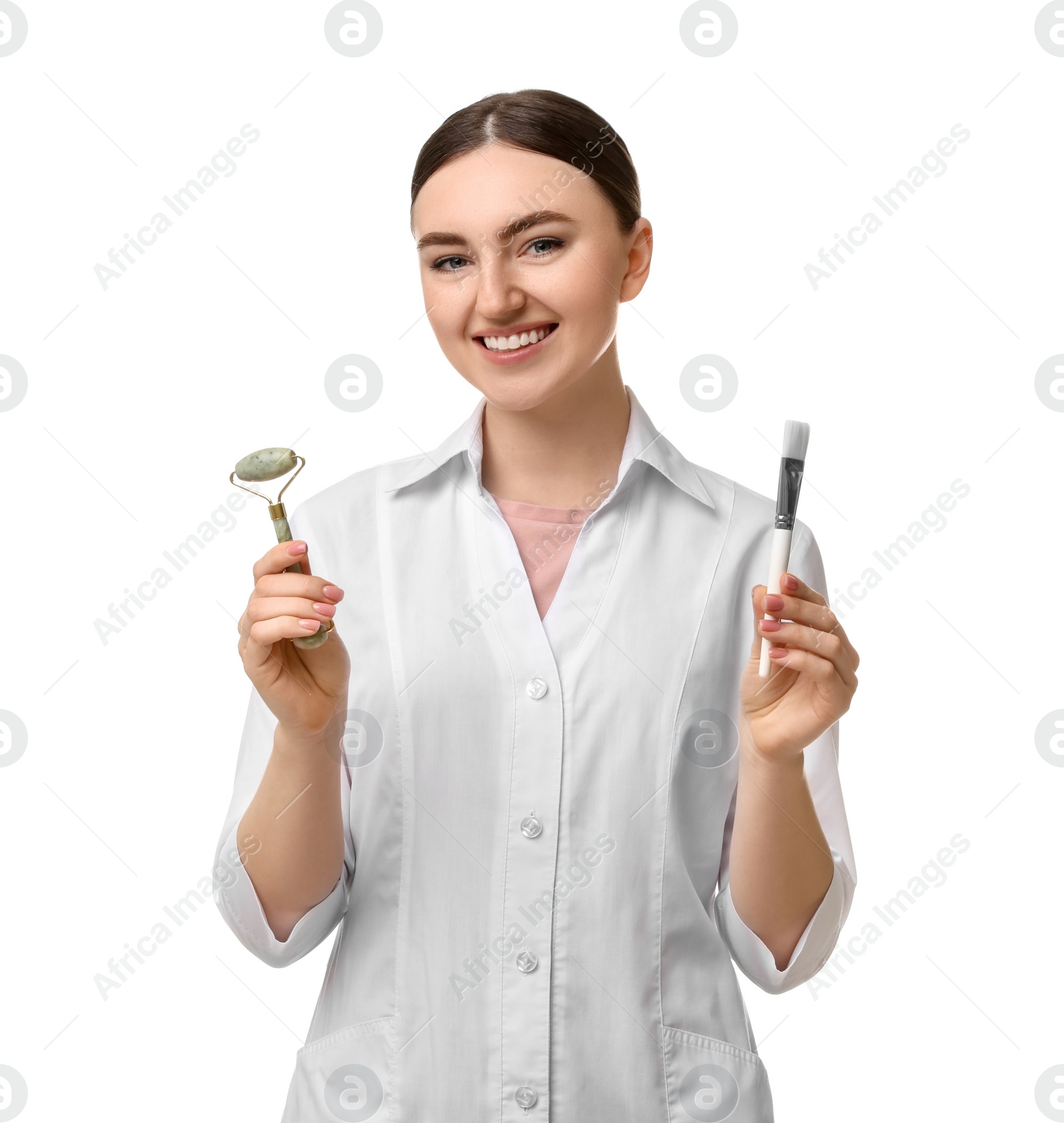 Photo of Cosmetologist with cosmetic brush and facial roller on white background