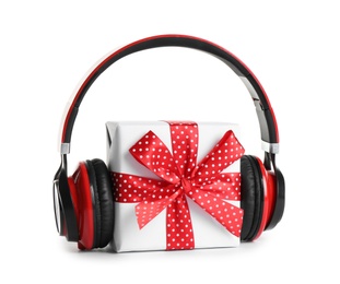 Gift box with headphones isolated on white. Christmas music concept