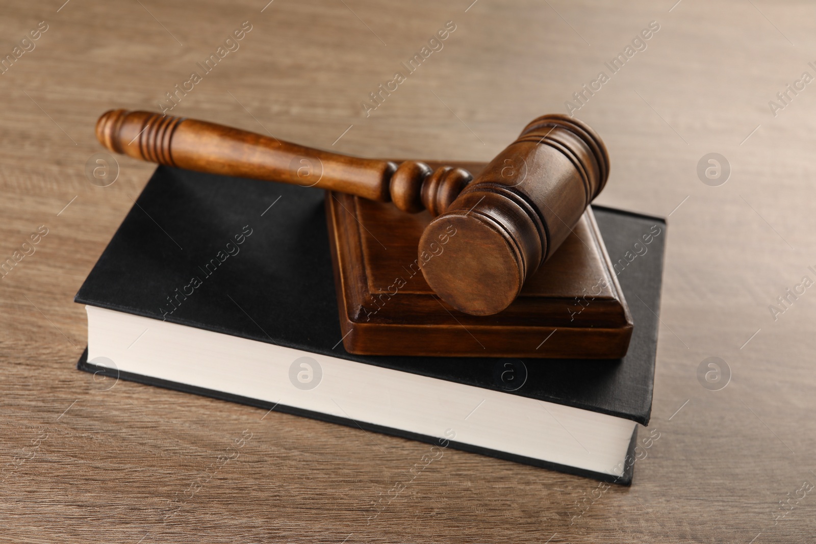 Photo of Law concept. Mallet and book on wooden table, closeup