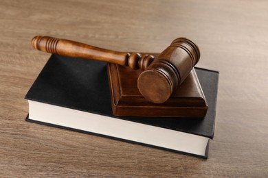 Photo of Law concept. Mallet and book on wooden table, closeup