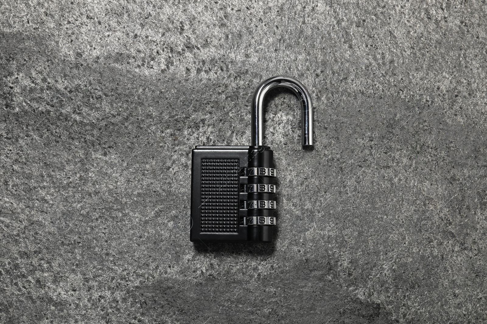 Photo of One steel combination padlock on grey table, top view