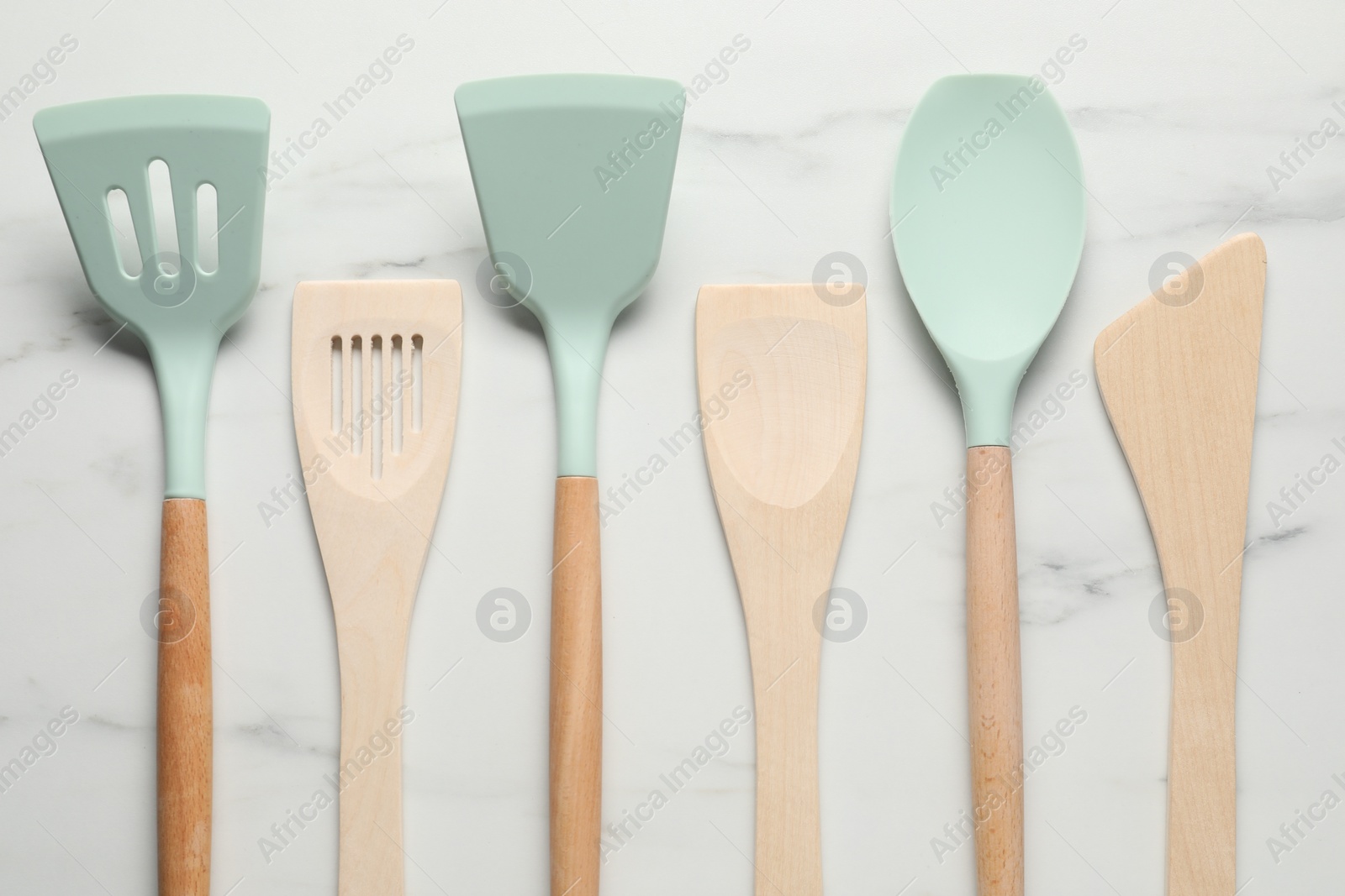 Photo of Different spatulas on white marble table, flat lay