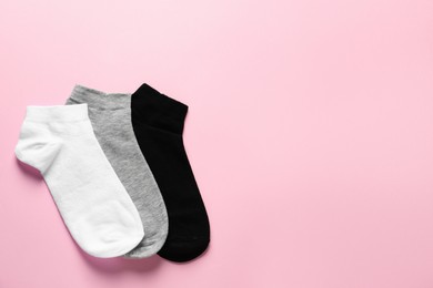 Photo of Different socks on pink background, flat lay. Space for text