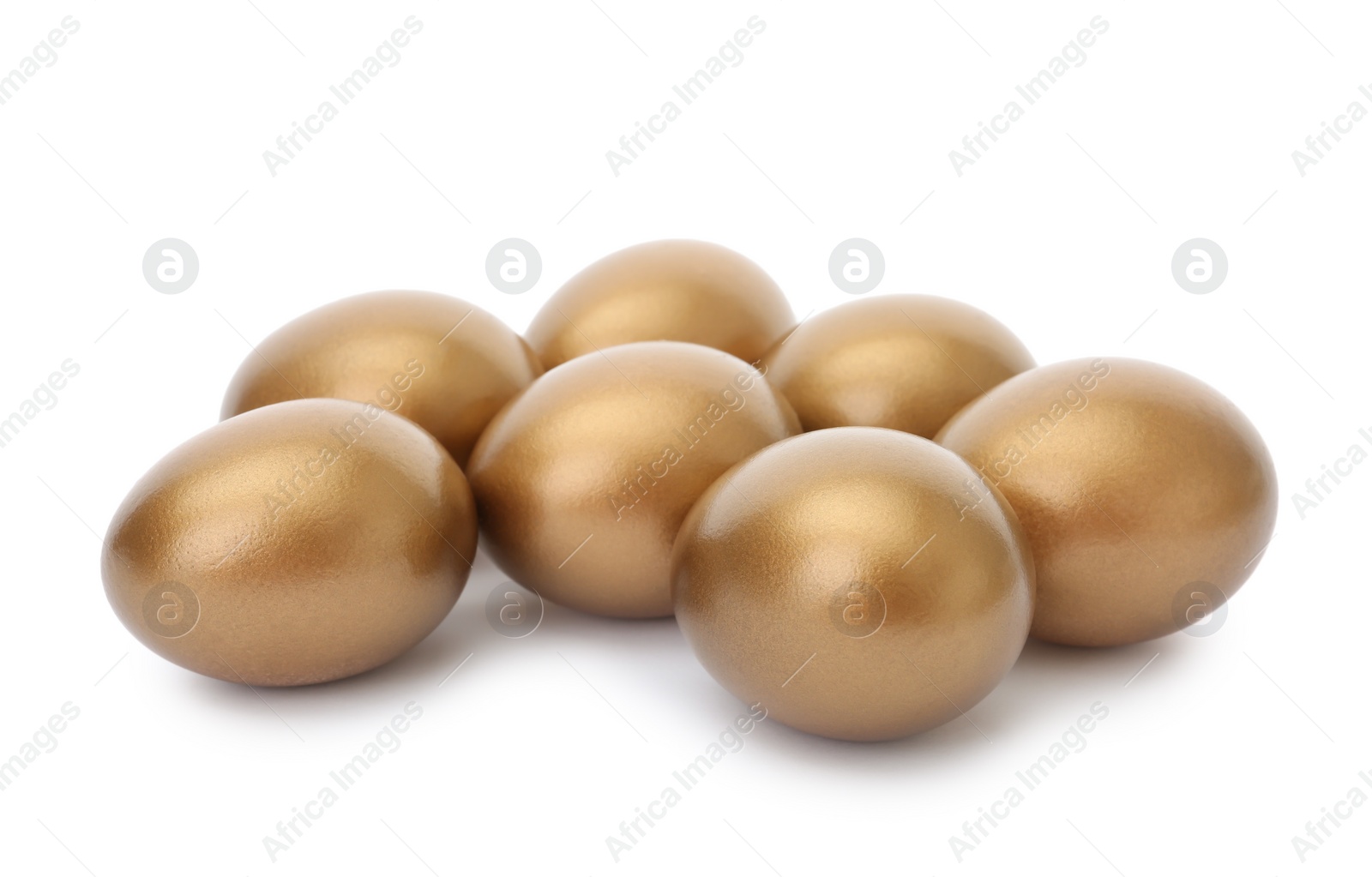 Photo of Many shiny golden eggs on white background