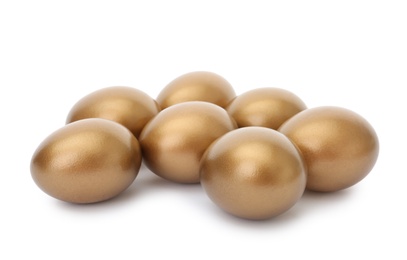 Photo of Many shiny golden eggs on white background