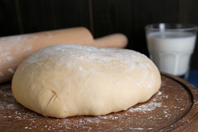 Photo of Fresh yeast dough with flour on table, closeup