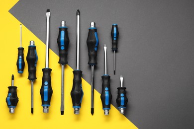 Photo of Set of screwdrivers on color background, flat lay. Space for text