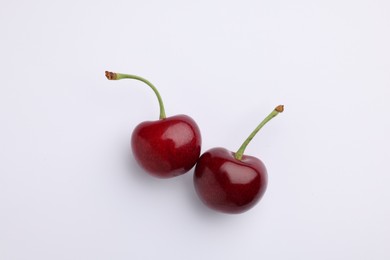 Two fresh sweet cherries on white background