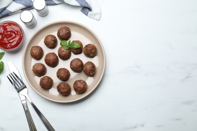 Tasty cooked meatballs with basil served on white table, flat lay, Space for text