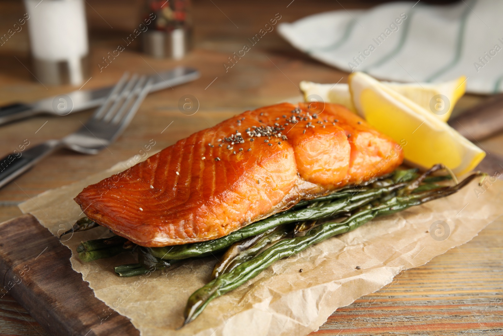 Photo of Tasty cooked salmon and vegetables served on wooden table. Healthy meals from air fryer