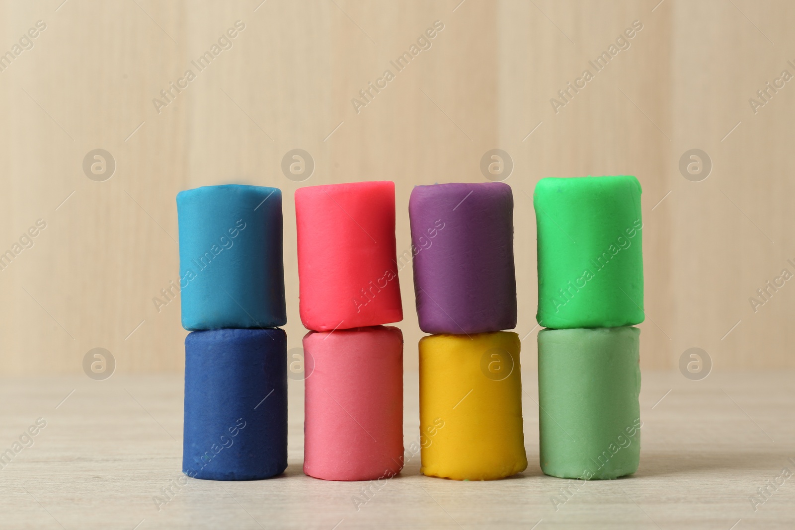 Photo of Different color play dough on white wooden table