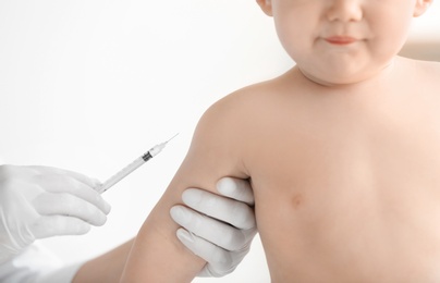 Doctor vaccinating baby in clinic, closeup