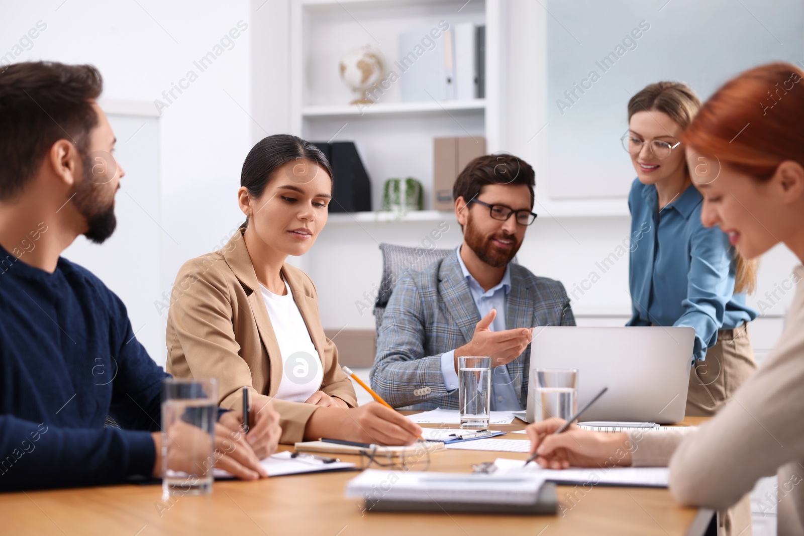 Photo of Team of employees working together in office