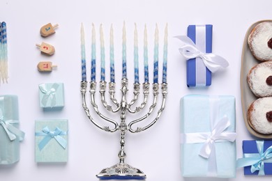 Photo of Flat lay composition with Hanukkah menorah and gift boxes on light background