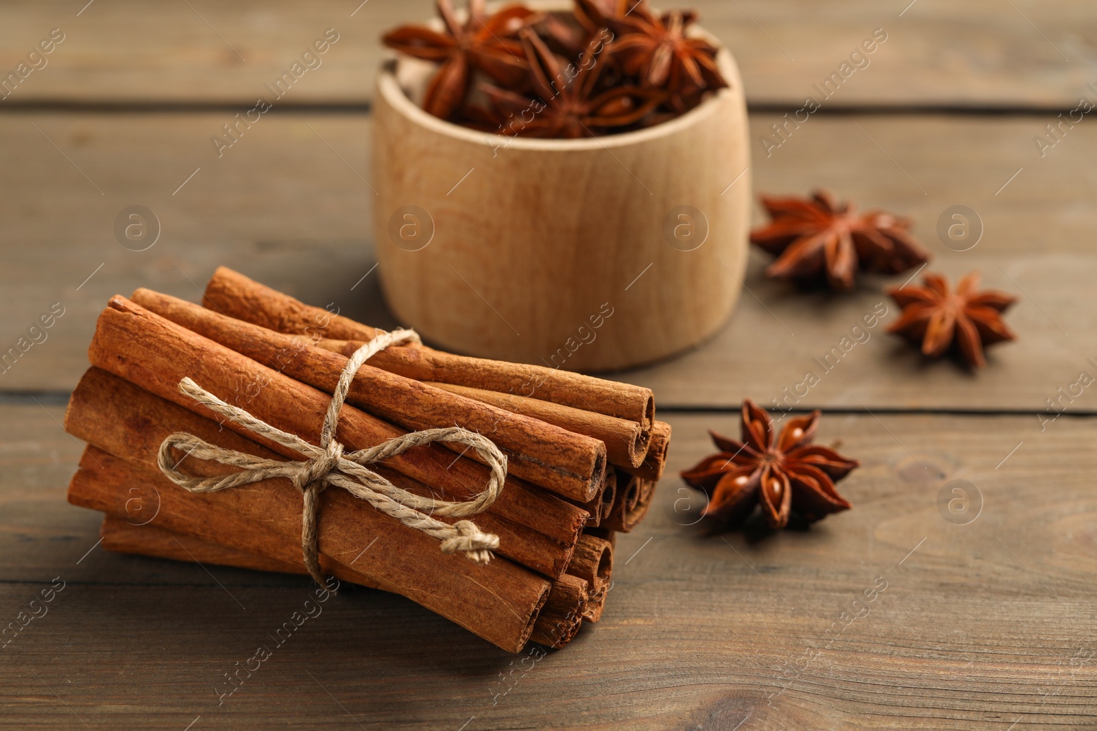 Photo of Cinnamon sticks and star anise on wooden table, closeup