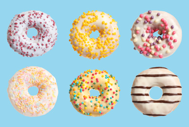 Image of Set with delicious glazed donuts on light blue background